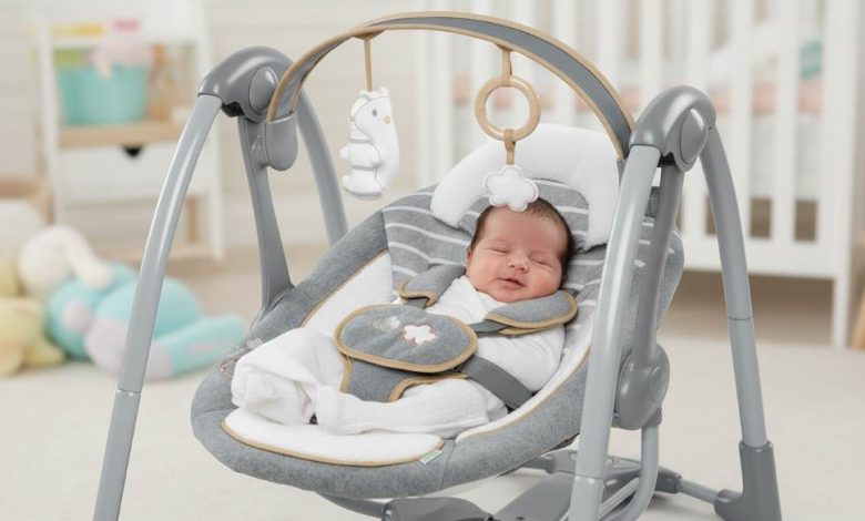 Happy newborn relaxing in plush Ingenuity Swing ‘n Go Deluxe portable baby swing with toy bar
